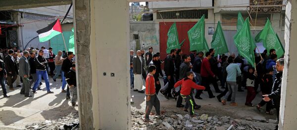 Palestinian Hamas supporters march with green Hamas and national flags in Beit Hanoun, northern Gaza Strip. - Sputnik International