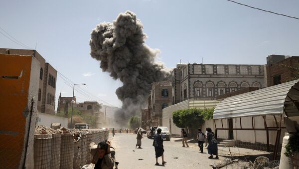 People flee as smoke billows after air strikes hit the house of Yemen's former President Ali Abdullah Saleh in Sanaa May 10, 2015 - Sputnik International