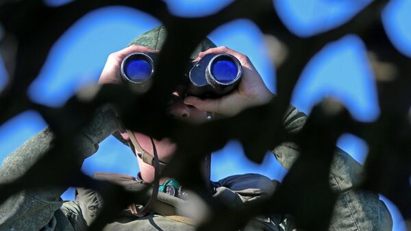 Russian soldier looking through binoculars during military exercise in the Kaliningrad Region. File photo. - Sputnik International
