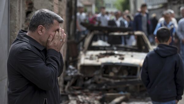 A man reacts next to a burnt out vehicle in Kumanovo, Macedonia - Sputnik International