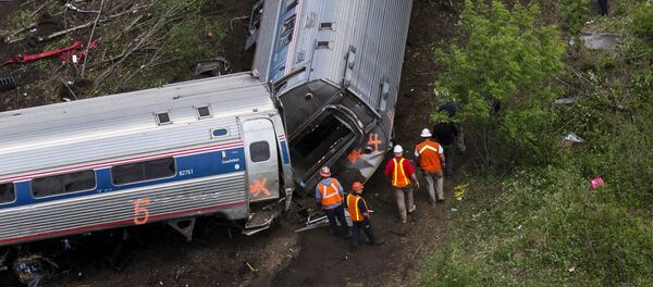 Emergency workers and Amtrak personnel inspect a derailed Amtrak train in Philadelphia, Pennsylvania May 13, 2015 - Sputnik International