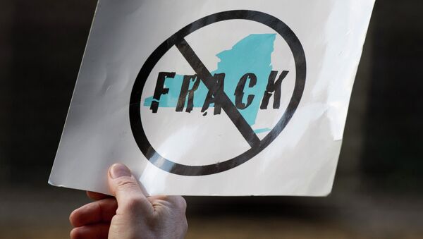 An opponent of the hydraulic fracturing holds a sign during a demonstration at the site of a Democratic party fundraiser March 20, 2014 in New York - Sputnik International