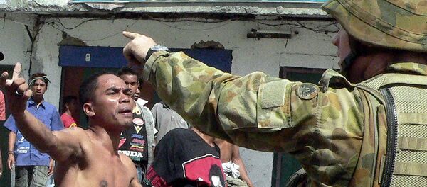 An Australian soldier asks gang members to clear an area as they were throwing stones at a refugee camp in Dili, 28 June 2006 An Australian soldier asks gang members to clear an area as they were throwing stones at a refugee camp in Dili, 28 June 2006 - Sputnik International