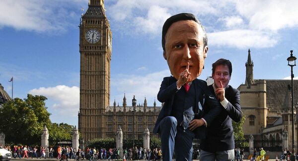 Free speech campaigners, one wearing a mask depicting British Prime Minister David Cameron, left, and another wearing a mask depicting ex-LibDem leader Nick Clegg, stage a photo op for the media during a protest opposite from the Houses of Parliament in central London in 2013.  - Sputnik International