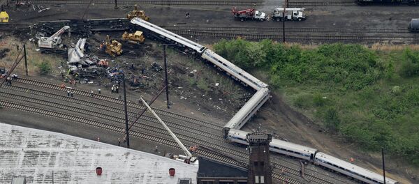 Emergency personnel work at the scene of a deadly train derailment, Wednesday, May 13, 2015, in Philadelphia - Sputnik International