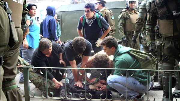 Demonstrators help one of the two young students killed at the end of the National March for Education in Valparaiso, Chile, on May 14, 2015 - Sputnik International