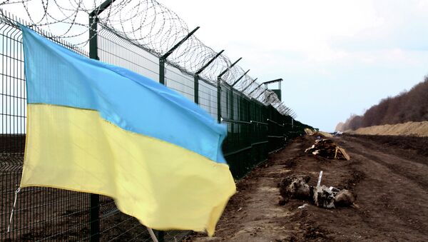 A Ukrainian national flag is attached to the fence on the Ukrainian-Russian border near Hoptivka, Kharkiv region, eastern Ukraine - Sputnik International
