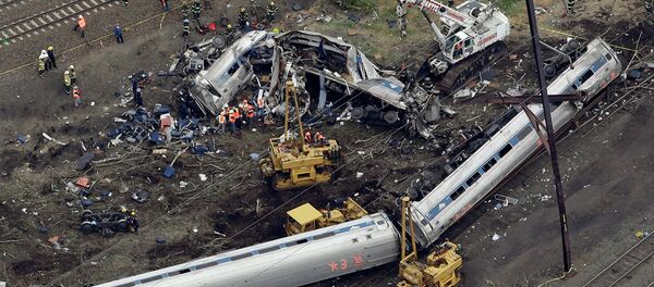 Emergency personnel work at the scene of a deadly train derailment, Wednesday, May 13, 2015, in Philadelphia - Sputnik International