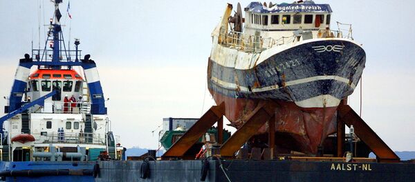 A picture taken on July 13, 2004 shows the wreckage of French trawler Bugaled Breizh, installed at a barge, as it is being towed, and escorted by military ships, towards a French military port of Brest. file photo - Sputnik International