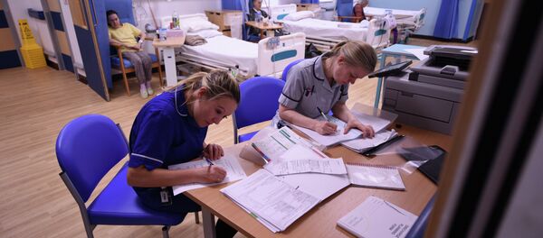 Members of clinical staff complete paperwork in the Accident and Emergency department of the 'Royal Albert Edward Infirmary' in Wigan, north west England on April 2, 2015 - Sputnik International