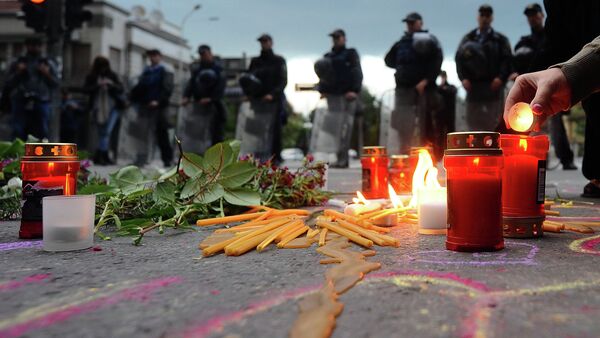 People light candles in front of the riot policemen to commemorate policemen who were killed after fighting between Macedonian police and an armed group in the town of Kumanovo , in Skopje on May 11, 2015 - Sputnik International