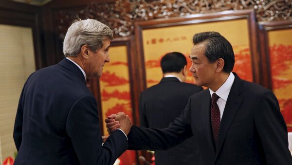 US Secretary of State John Kerry (L) shakes hands with Chinese Foreign Minister Wang Yi as he meets Chinese Premier Li Keqiang (C) at the Zhongnanhai Leadership Compound in Beijing, China, May 16, 2015 - Sputnik International