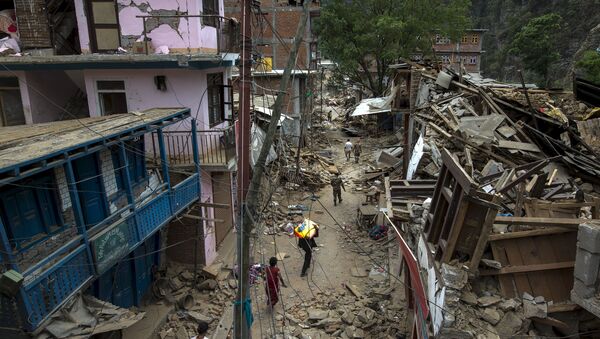 Local residents walk past collapsed buildings after Tuesday's earthquake at Singati Village, in Dolakha, Nepal, May 15, 2015 - Sputnik International