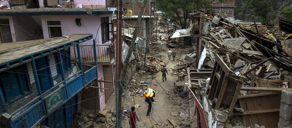Local residents walk past collapsed buildings after Tuesday's earthquake at Singati Village, in Dolakha, Nepal, May 15, 2015 Local residents walk past collapsed buildings after Tuesday's earthquake at Singati Village, in Dolakha, Nepal, May 15, 2015 - Sputnik International