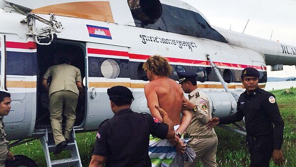 Russian Sergei Polonsky (C) is escorted by Cambodian police officials into a helicopter on an island in Preah Sihanouk province on May 15, 2015 - Sputnik International