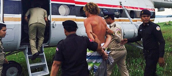 Russian Sergei Polonsky (C) is escorted by Cambodian police officials into a helicopter on an island in Preah Sihanouk province on May 15, 2015 Russian Sergei Polonsky (C) is escorted by Cambodian police officials into a helicopter on an island in Preah Sihanouk province on May 15, 2015 - Sputnik International