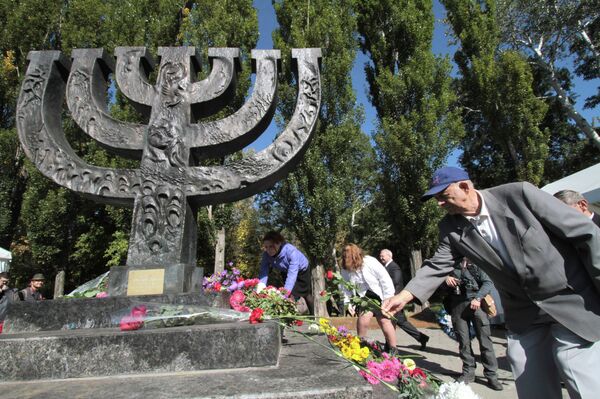 People lay flowers at the monument at the Babi Yar national historical and memorial park during a commemorative rally. People lay flowers at the monument at the Babi Yar national historical and memorial park during a commemorative rally. - Sputnik International