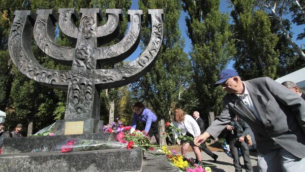 People lay flowers at the monument at the Babi Yar national historical and memorial park during a commemorative rally. - Sputnik International