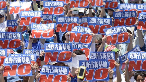 Protesters raise placards during a rally to oppose the transfer of a key U.S. military base within the prefecture, at a baseball stadium in the prefectural capital Naha on Japan's southern island of Okinawa, in this photo taken by Kyodo May 17, 2015 - Sputnik International