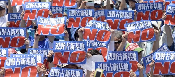 Protesters raise placards during a rally to oppose the transfer of a key U.S. military base within the prefecture, at a baseball stadium in the prefectural capital Naha on Japan's southern island of Okinawa, in this photo taken by Kyodo May 17, 2015 - Sputnik International