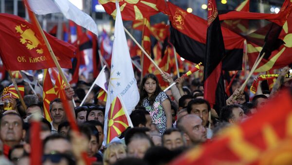 Supporters of the ruling coalition wave national and party flags, during a rally in front of the Parliament building in Skopje, Macedonia, Monday, May 18, 2015 - Sputnik International