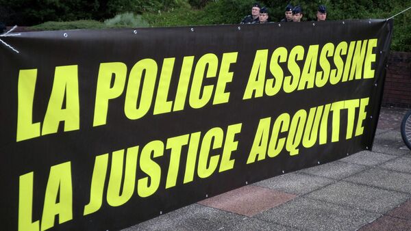 Policemen stand behind a banner reading The police kill, Justice acquitts displayed near the courthouse in Bobigny, outside Paris - Sputnik International