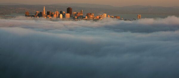 The skyline of San Francisco appears above the evening fog as the suns sets on the Marin Headlands in Sausalito, California - Sputnik International