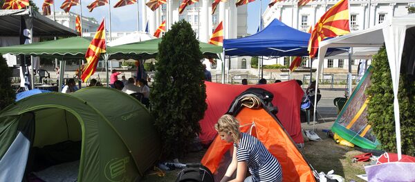 A woman stands next to her tent in a makeshift camp in front of the government building where protesters have said they will not leave until the government resigns, in Skopje A woman stands next to her tent in a makeshift camp in front of the government building where protesters have said they will not leave until the government resigns, in Skopje - Sputnik International