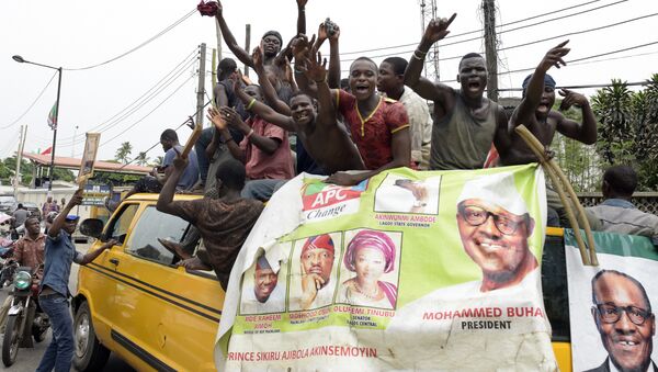 Supporters of newly-elected Nigerian President Muhammadu Buhari sit on top of a bus as they celebrate the victory their candidate in Lagos on April 1, 2015 - Sputnik International