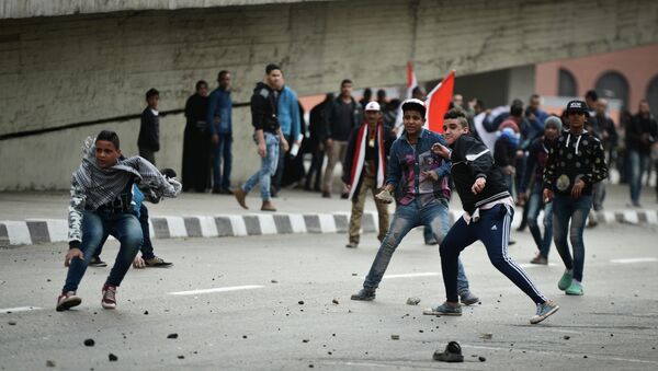 Supporters of Egyptian President Abdel Fattah al-Sisi clash with anti-government protesters (unseen) following demonstrations in Cairo on January 25, 2015, marking the fourth anniversary of the 2011 uprising that ousted veteran autocrat Hosni Mubarak - Sputnik International