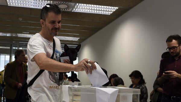 A man carrying a dog casts his ballots in the Spain's municipal and regional elections at a polling station in Barcelona on May 24, 2015 - Sputnik International