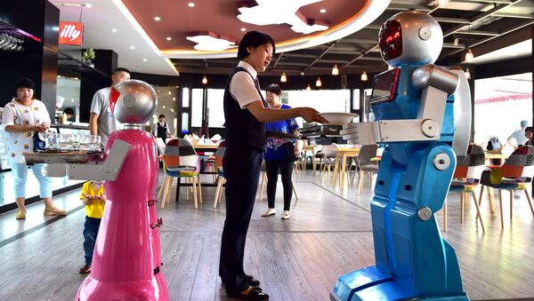 A waitress places dishes on a tray carried by a robot couple at a restaurant in Jinhua, Zhejiang province, China, May 18, 2015 - Sputnik International