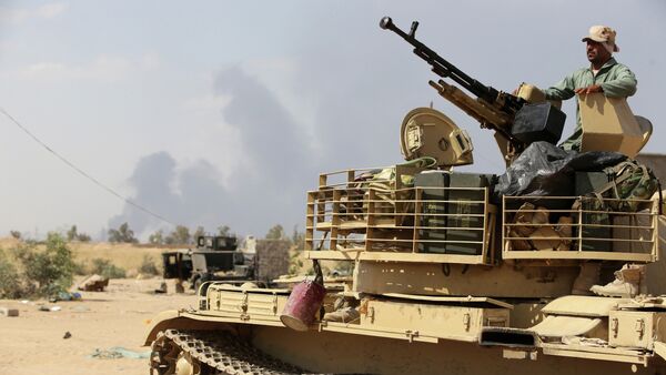 An Iraqi army member mans a tank on the outskirts of Baiji refinery north of Tikrit, during a joint operation between the army and popular mobilisation units to retake the remaining area of the Baiji oil refinery from Islamic State (IS) group jihadists, on May 24, 2015 - Sputnik International