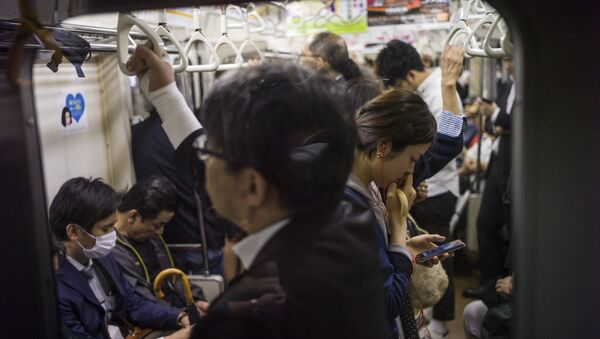 A woman reads on her smartphone while riding the subway in Tokyo on May 12, 2015 - Sputnik International