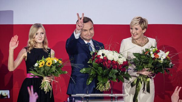 Andrzej Duda (C), presidential candidate of Law and Justice (PiS) right wing opposition party celebrates with his wife Agata (R) and daughter Kinga (L) after the announcement of the exit poll results of the second round of the presidential election in Warsaw, on May 24, 2015 - Sputnik International