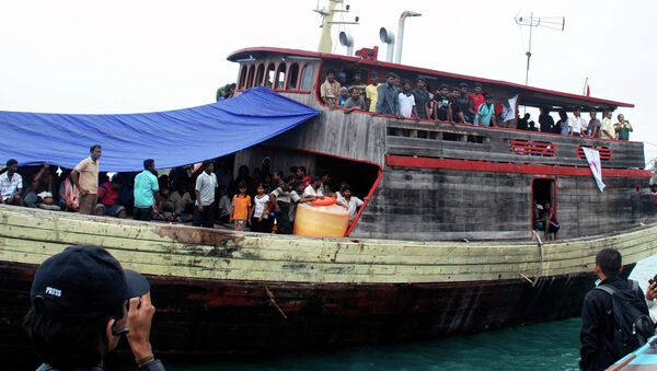 Sri Lankan migrants are seen on board of a wooden boat as they dock at a port in Cilegon, Banten province, Indonesia, Monday, Oct. 12, 2009 - Sputnik International