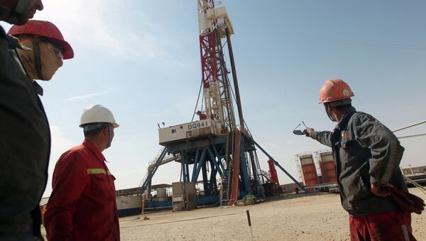 Gazprom employees look at a drilling platform for Gazprom company. File photo - Sputnik International