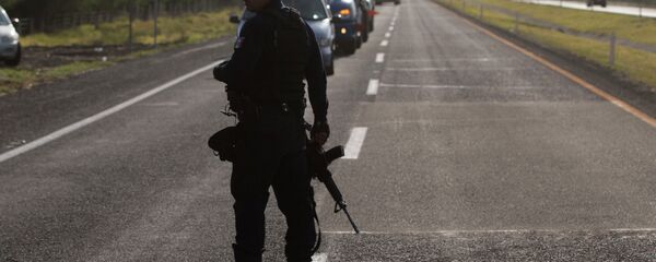 Mexican state police stop traffic, near the entrance of Rancho del Sol, near Ecuanduero, in western Mexico, Friday, May 22, 2015 - Sputnik International