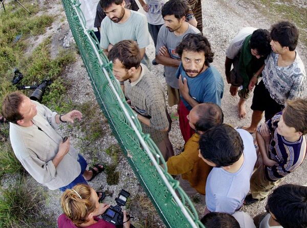 Asylum seekers at Australia's detention center on the island of Nauru gather on one side of a fence to talk with international journalists about their journey that brought them there. Asylum seekers at Australia's detention center on the island of Nauru gather on one side of a fence to talk with international journalists about their journey that brought them there. - Sputnik International