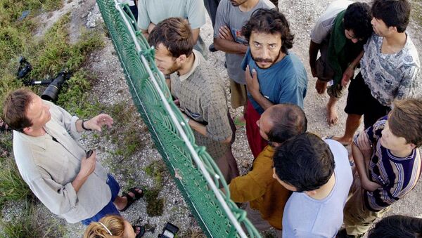 Asylum seekers at Australia's detention center on the island of Nauru gather on one side of a fence to talk with international journalists about their journey that brought them there. - Sputnik International