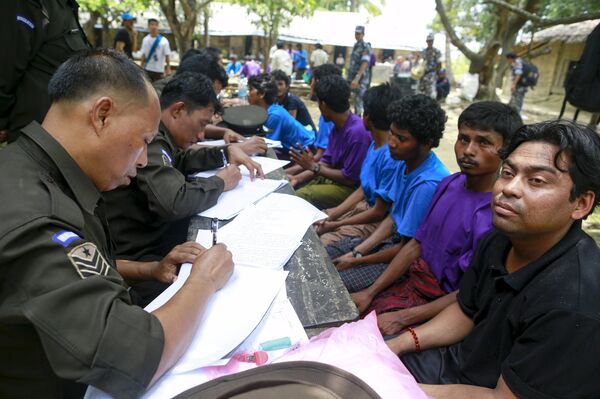 Rohingya Muslims from Myanmar, who were rescued by the Myanmar navy alongside Bangladesh refugees, are interviewed by immigration officers at a Muslim religious school used as a temporary refugee camp, at the Aletankyaw village in the Maungdaw township, in Rakhine state May 23, 2015 - Sputnik International