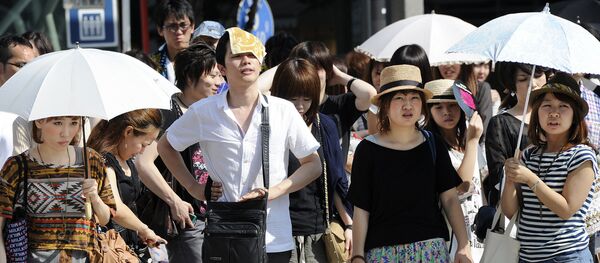 People wait for a green light at a crossing as they use umbrellas and hats to shade themselves from the sunshine in Tokyo People wait for a green light at a crossing as they use umbrellas and hats to shade themselves from the sunshine in Tokyo - Sputnik International