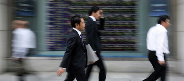 People walk past an electronic stock board of a securities firm in Tokyo. People walk past an electronic stock board of a securities firm in Tokyo. - Sputnik International