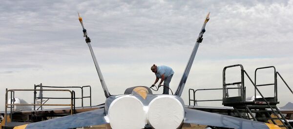 Preservation servicer Katy Shank sprays a sealing paint on a former NAVY Blue Angel F-18 at the 309th Aerospace Maintenance and Regeneration Group boneyard in Tucson, Ariz Preservation servicer Katy Shank sprays a sealing paint on a former NAVY Blue Angel F-18 at the 309th Aerospace Maintenance and Regeneration Group boneyard in Tucson, Ariz - Sputnik International