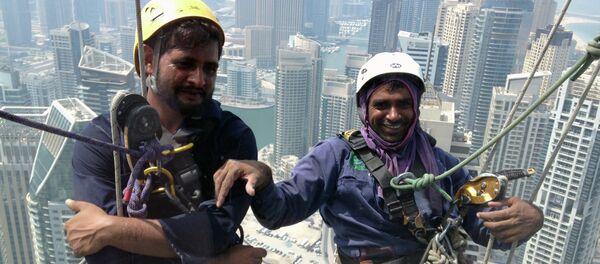 Pakistani window cleaners work on the facade of a building in the Gulf emirate of Dubai Pakistani window cleaners work on the facade of a building in the Gulf emirate of Dubai - Sputnik International