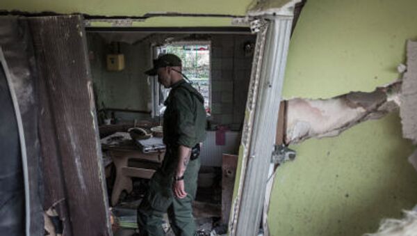 A militia man of the Donetsk People's Republic examines a house destroyed by an attack of the Ukrainian troops on Gorlovka, Donetsk Region. - Sputnik International