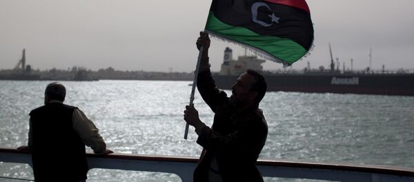 A man holds a pre Moammar Gadhafi flag. - Sputnik International