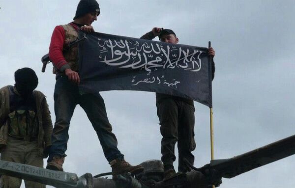 Rebels from al-Qaida-affiliated Jabhat al-Nusra, also known as the Nusra Front, wave their brigade flag, as they step on the top of a Syrian air force helicopter. Rebels from al-Qaida-affiliated Jabhat al-Nusra, also known as the Nusra Front, wave their brigade flag, as they step on the top of a Syrian air force helicopter. - Sputnik International