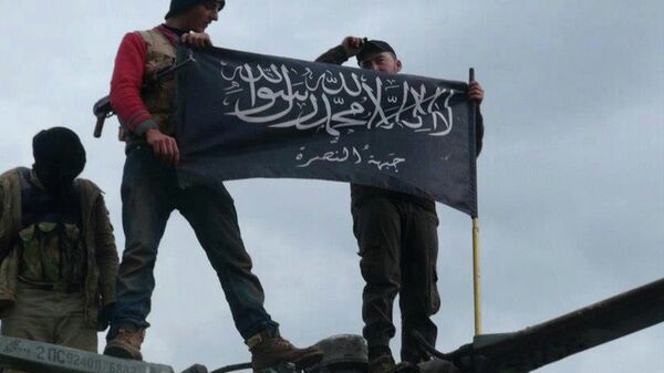 Rebels from al-Qaida-affiliated Jabhat al-Nusra, also known as the Nusra Front, wave their brigade flag, as they step on the top of a Syrian air force helicopter. - Sputnik International