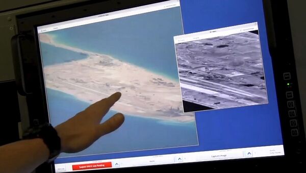 US Navy crewman aboard a P-8A Poseidon surveillance aircraft points to a computer screen purportedly showing Chinese construction on the reclaimed land of Fiery Cross Reef in the disputed Spratly Islands in the South China Sea in this still image from video provided by the United States Navy May 21, 2015 - Sputnik International